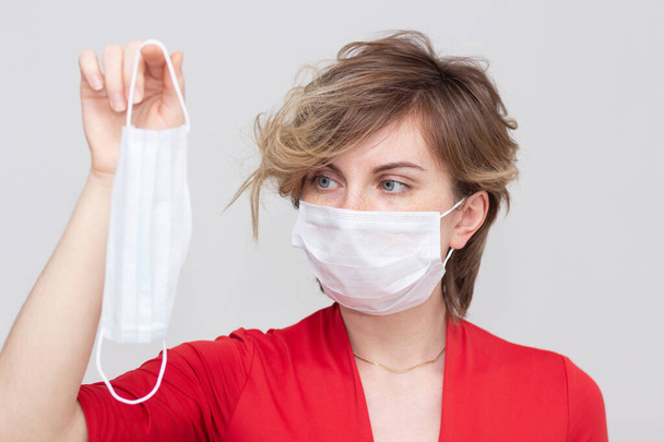 Cute girl wearing a health mask, looking straight, isolated on a white background, flu Epidemic, dust Allergy, virus protection. Concept of air pollution in the city, close-up - Photo, image