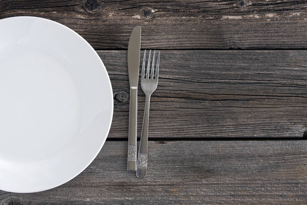 Empty plate with cutlery on wooden table - Fotoğraf, Görsel