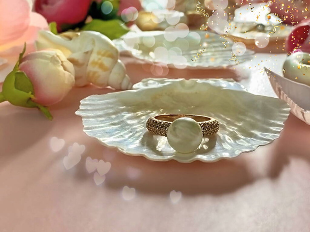 Biała perła z muszelką i płatkami róż, Biżuteria tło złoto białe perłowe pierścienie z muszelką i płatki róż na różowym tle akcesoria dla kobiet - Zdjęcie, obraz