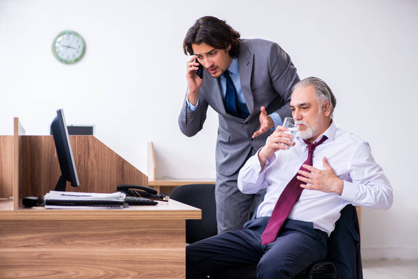 Mannelijke werknemer lijdt aan een hartaanval in het kantoor - Foto, afbeelding