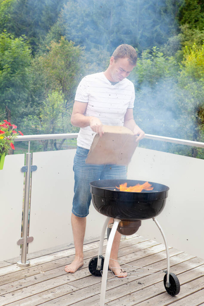 Grill master when heating the grill - Foto, Imagen