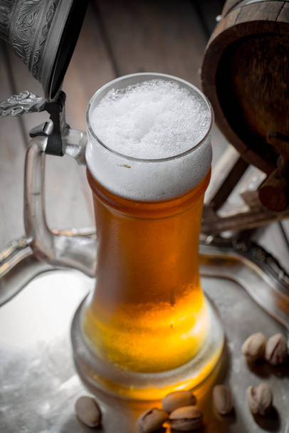 Cerveza ligera en un vaso sobre una mesa en composición con accesorios sobre un fondo viejo
 - Foto, Imagen