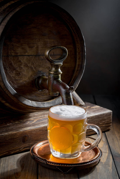 Cerveza ligera en un vaso sobre una mesa en composición con accesorios sobre un fondo viejo
 - Foto, imagen