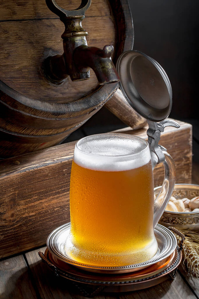 Light beer in a glass on a table in composition with accessories on an old background - Photo, image