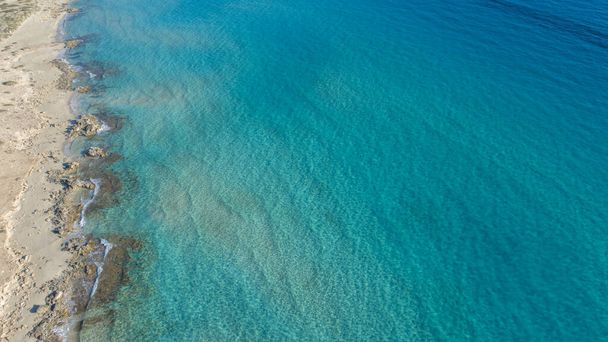 γαλαζοπράσινη παραλία με βράχια και βλάστηση από τα μάτια ενός πουλιού στο νησί - Φωτογραφία, εικόνα