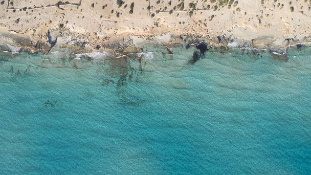 γαλαζοπράσινη παραλία με βράχια και βλάστηση από τα μάτια ενός πουλιού στο νησί - Φωτογραφία, εικόνα