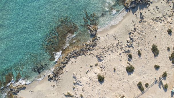 Tyrkysová mořská pláž se skalami a vegetací z ptačího pohledu na ostrov - Fotografie, Obrázek