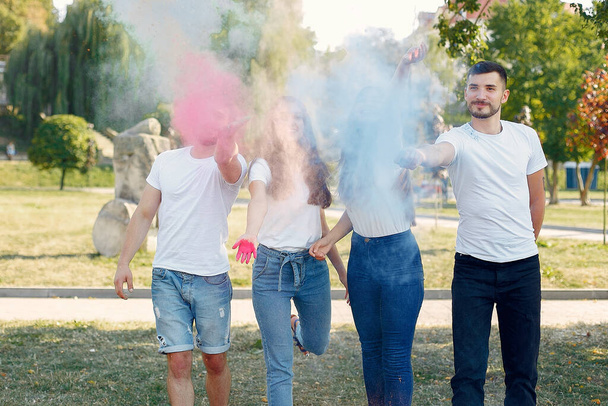 People have fun in a park with holi paints - Фото, изображение