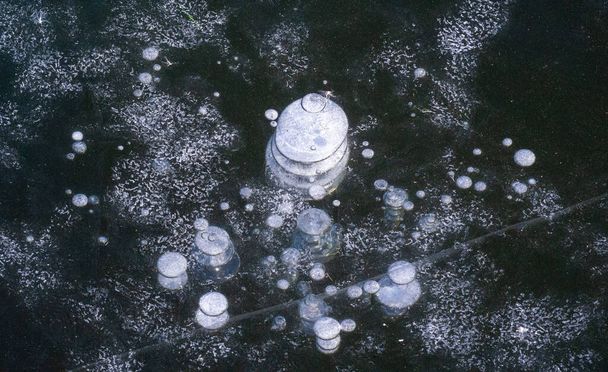 На улице мороз, на реке лед, ледяные пузырьки застряли во льду, необычайно красочная ледяная архитектура - Фото, изображение