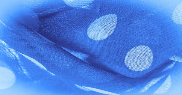 Pozadí textura, dekorativní ozdoba, modrá polka-tečka hedvábné tkaniny, kulaté tečky na tkanině, které mají tvar nebo přibližně připomínají kruh nebo válec. - Fotografie, Obrázek