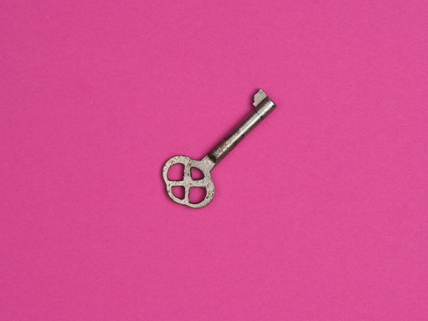 Old key on a pink background. The view from the top. - Foto, immagini