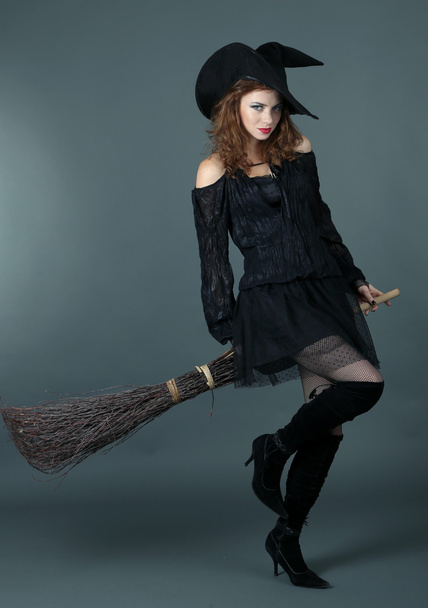 Halloween witch with broom on gray background - Фото, изображение