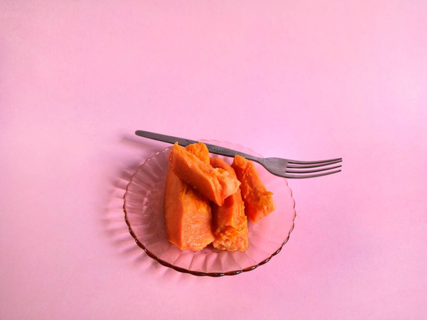 Кусочки папайи на розовом фоне. диета
 - Фото, изображение