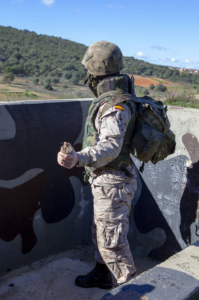 żołnierz w kamuflażu i kombinezonie ochronnym przygotowany do rzucenia granatem - Zdjęcie, obraz