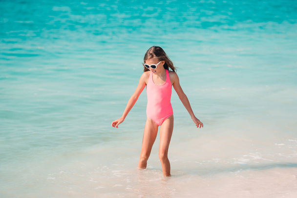 Schattig klein meisje veel plezier op tropisch strand tijdens vakantie - Foto, afbeelding