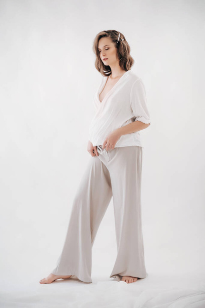 Beautiful Pregnant Woman Posing in white Studio   - 写真・画像