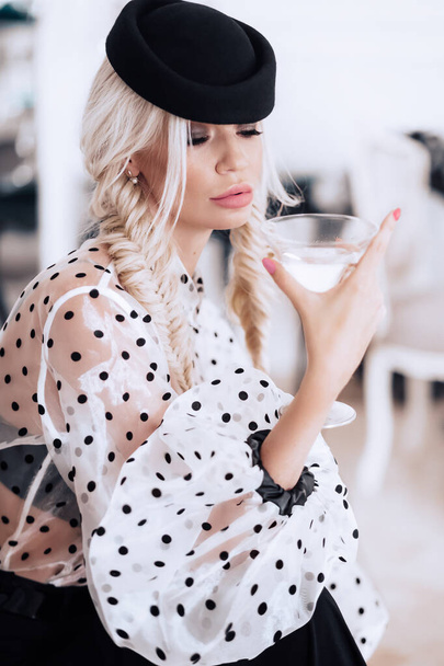 портрет красивої блондинки в точковій блузці з напоєм
 - Фото, зображення