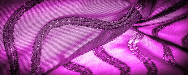 el ornamento de la decoración, la tela transparente es de color púrpura-rojo con rayas brillantes innatas, el material que permite que la luz pase a través de él para que los objetos detrás sean claramente visibles
. - Foto, imagen