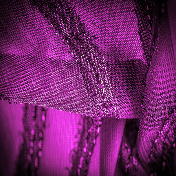 het ornament van het decor, de transparante stof is paars-rood met felle aangeboren strepen, het materiaal waardoor het licht door het zodat de objecten achter zijn duidelijk zichtbaar. - Foto, afbeelding