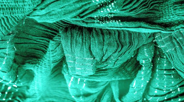 Arka plan resminin dokusu suyun altındaki kumaşın rengi, yeşil-mavi kıvrımlı kumaş, paralel veya çapraz kıvrımlı, tırtıklı katlı kumaş; böyle bir kumaştan çıkan ürünler.. - Fotoğraf, Görsel