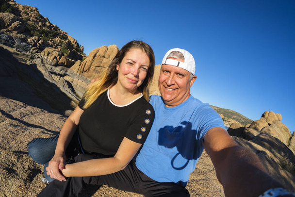 Attractive middle age couple enjoying the natural beauty of Watson Lake in Prescott, Arizona in the late afternoon. - Zdjęcie, obraz