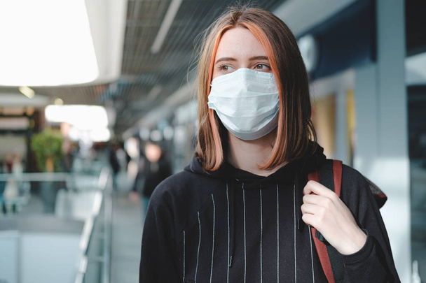 Woman in a protective face mask at public place. Coronavirus, COVID-19 spread prevention concept, responsible social behaviour of a citizen - Photo, Image