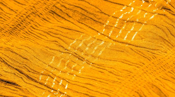 La textura del patrón de fondo, la decoración del ornamento, la tela ondulada de color amarillo dorado, la tela con pliegues paralelos o diagonales de pliegues dentados; productos de dicha tela. - Foto, imagen