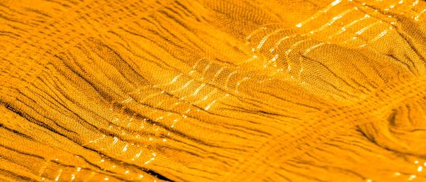 The texture of the background pattern, ornament decor, golden yellow corrugated fabric, fabric with parallel or diagonal folds of serrated folds; products from such a fabric. - Photo, Image
