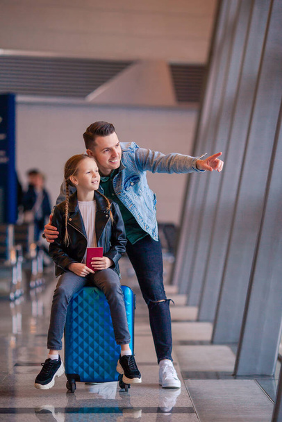 Famille heureuse avec bagage et carte d'embarquement à l'aéroport en attente d'embarquement
 - Photo, image