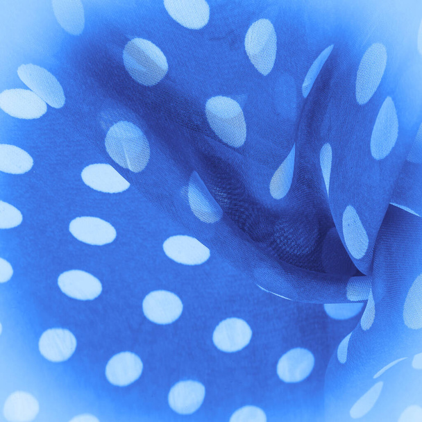 Achtergrond textuur, decoratieve ornament, blauwe polka-dot zijde weefsel, ronde stippen op stof die een vorm hebben of ongeveer lijken op een cirkel of cilinder. - Foto, afbeelding