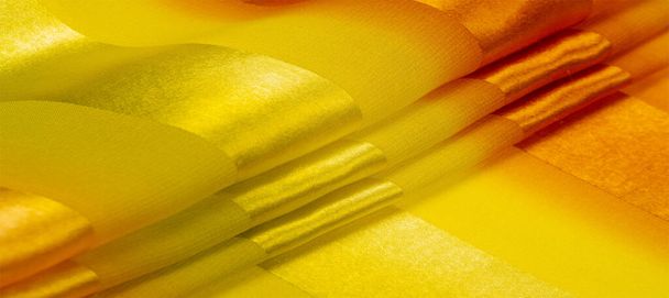 Tekstuuri, tausta, keltainen silkkiraidallinen kangas, jossa on metallinen kiilto. Jos sinulla on huonolla tuulella, tämä kangas nostaa sen ennennäkemättömän korkeuksiin. Projektisi onnistuu.. - Valokuva, kuva