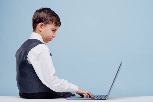 Focused small boy using laptop in studio - Фото, зображення