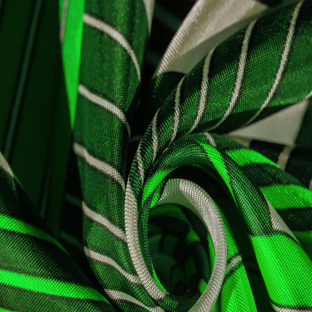 Texture, tissu de soie avec un motif rayé vert. La conception de ce tissu est consacrée à une mosaïque patchwork dans le style d'un lapin blanc, représentant ce à quoi pourrait ressembler un gilet de conte de fées. - Photo, image