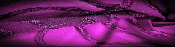 el ornamento de la decoración, la tela transparente es de color púrpura-rojo con rayas brillantes innatas, el material que permite que la luz pase a través de él para que los objetos detrás sean claramente visibles
. - Foto, imagen