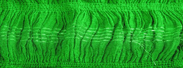 Tekstura tła, ozdobny wystrój, szmaragdowa zielona tkanina falista centrowana, tkanina o równoległych lub ukośnych fałdach ząbkowanych fałd; produkty z takiej tkaniny. - Zdjęcie, obraz