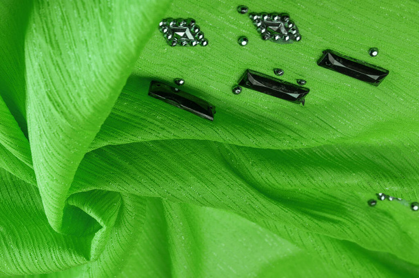 Textura de design de fundo, padrão de seda, tecido verde com pedras facetadas decorativas coladas - Foto, Imagem