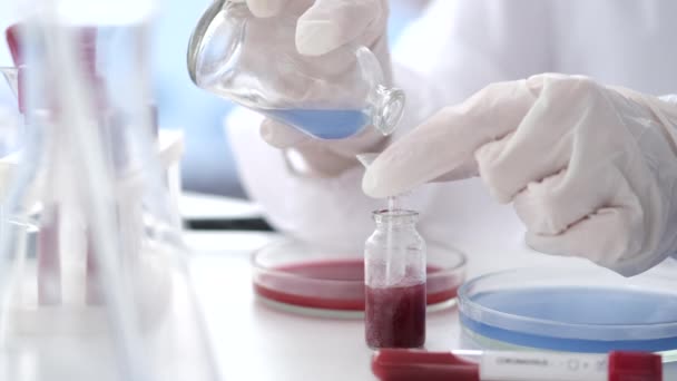 Un scientifique en combinaison fait un test de coronavirus dans un labo
 - Séquence, vidéo