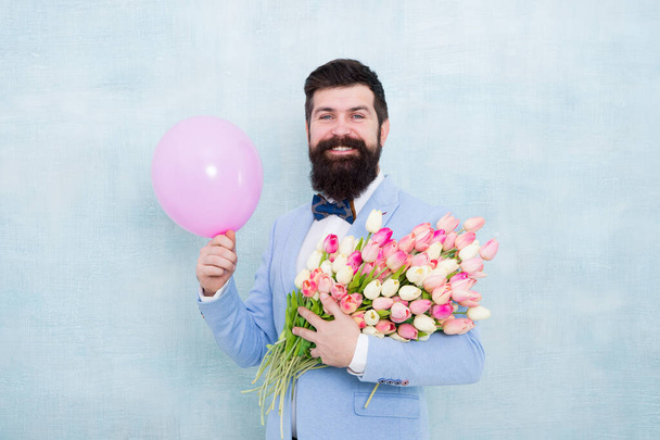 Birthday gifts for her. Happy hipster hold flowers and birthday balloon. Tulip bouquet for birthday greetings. Valentines day. Womens day. Anniversary celebration. Wishing happy birthday - Photo, image