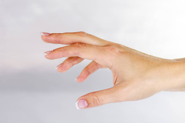 De hand van een vrouw, geopend, lijkt naar iets te reiken of zal iets voelen.. - Foto, afbeelding