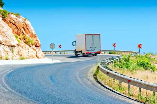 vrachtwagen rijden op een bergweg op een zonnige dag - Foto, afbeelding