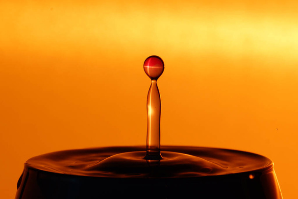 splash of water on orange background - Fotoğraf, Görsel