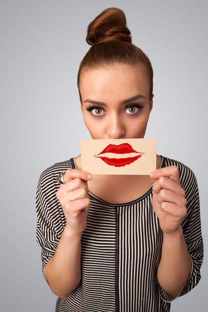 Happy pretty woman holding card with kiss lipstick mark - Foto, Imagen