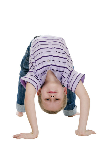 "Frontal full-body view of a seven-year-old boy against a white background in the sporty exercise ""Bridge"" looking neutrally into the camera" - Fotografie, Obrázek