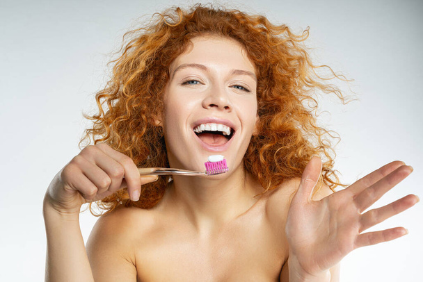 Закройте счастливую девушку, которая держит зубную щётку
 - Фото, изображение
