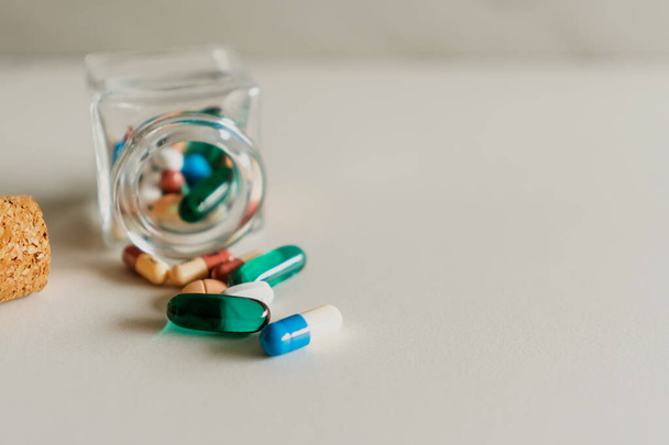 Top view of medicine tabletta öntsük tabletták palack márvány textúra fehér háttér. Egészségügyi ellátás orvosi életmód trend koncepció. - Fotó, kép