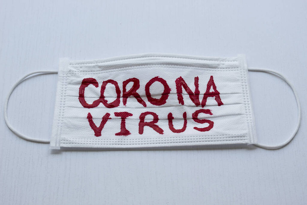 Zamknięta do białej maski z czerwonym napisem CORONAVIRUS i białą czarną ziemią. COVID-2019 - Zdjęcie, obraz