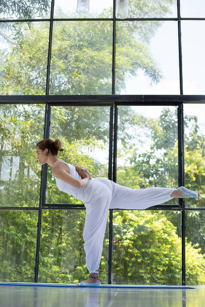 жінка робить йогу в лебединій позі Позиція Ханса Парсвотана
 - Фото, зображення