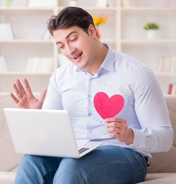 Jongeman doet huwelijksaanzoek via internet laptop - Foto, afbeelding