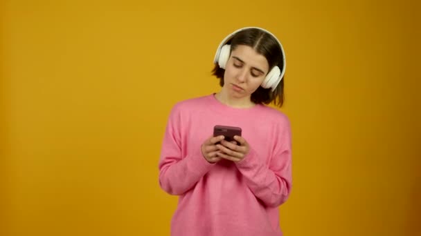 Girl with smartphone listening music in headphones - Felvétel, videó