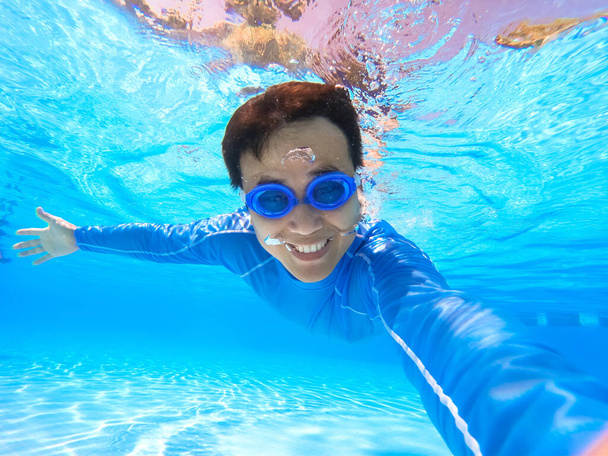 Asyalı adam selfie çek ve yüzme havuzunda sana mutlu bir şekilde bak. - Fotoğraf, Görsel